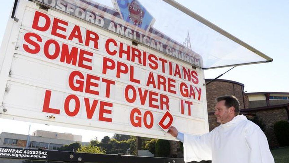 Father Rod Bower puts a letter on a church billboard which reads: "Dear Christians, some ppl are gay, get over it, love god."