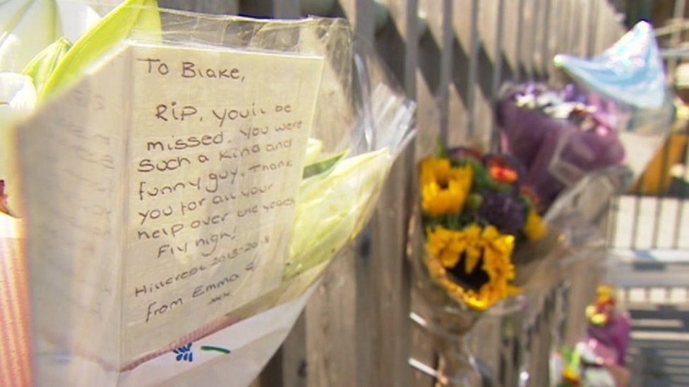 Flowers and messages pinned to gates at school