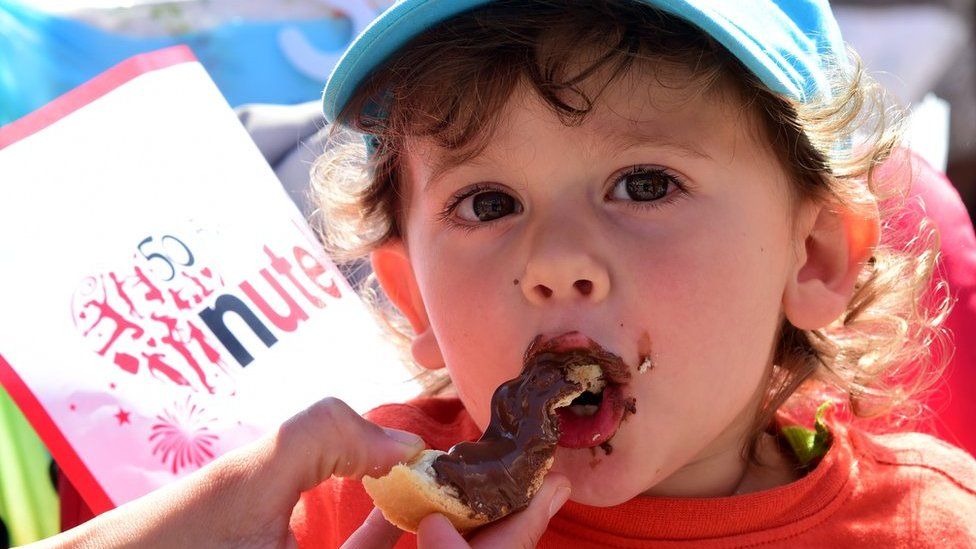 A child eats a tartine of Nutella on May 17, 2014 in Alba, northern Italy, during the celebrations of the 50th anniversary of Nutella