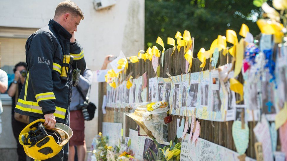 Firefighter looks at tributes during the silence