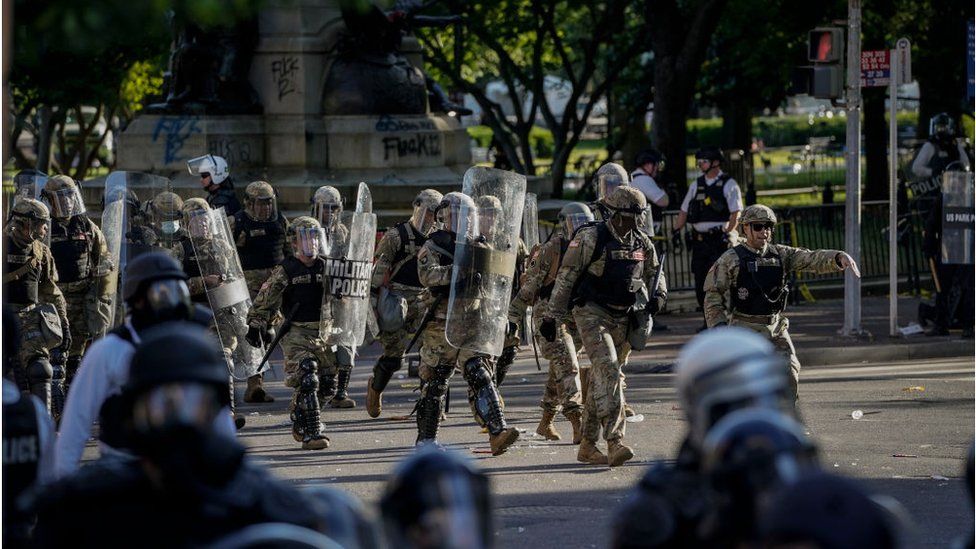 National Guard troops are seen moving behind the US Park Police