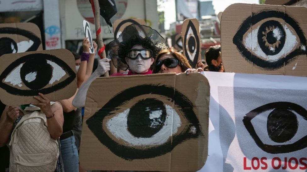 Люди протестуют против правительства президента Чили Себастьяна Пиньеры с табличками, изображающими глаза — имея в виду демонстрантов, глаза которых попали под полицейские пули — в Сантьяго, 18 декабря 2019 г.