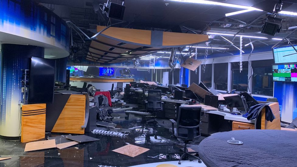 Newsroom with ceiling tiles fallen and broken computers