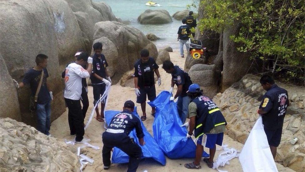 Thai workers carry the bodies of the two murdered British tourists on Koh Tao island