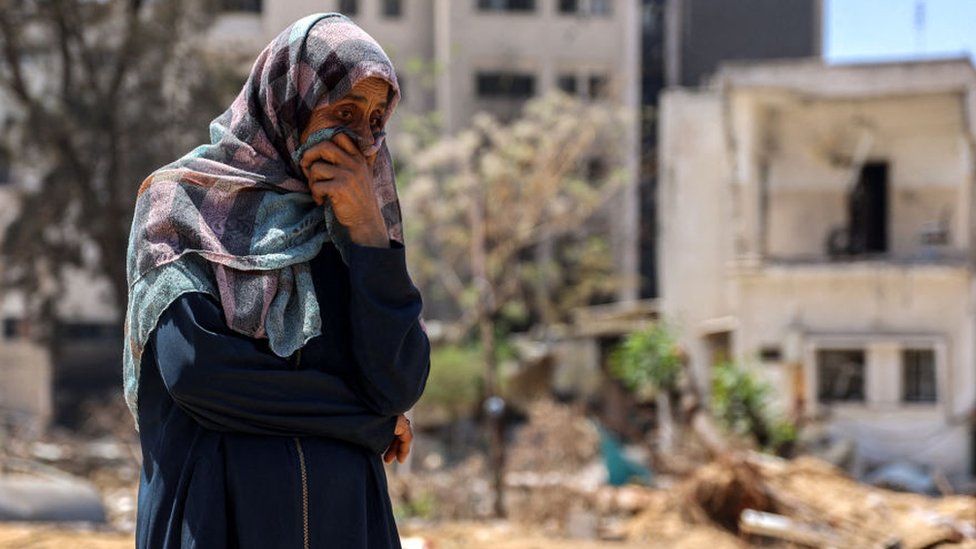 A woman reacts as she watches Palestinian forensic experts and others search for bodies of dead people in the vicinity of Al-Shifa Hospital in Gaza City