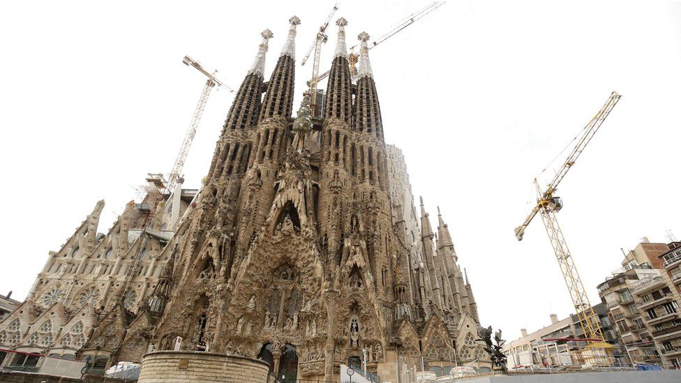Tourists stand outside the Sagrada Familia in Barcelona