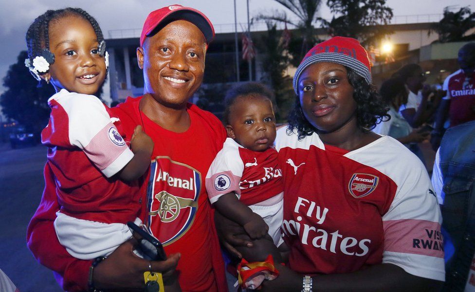 A family, fans of Arsenal, pose for a photo during the arrival of Former soccer coach Arsene Wenger at the Roberts International Airport in Harbel, Liberia, 22 August 2018.