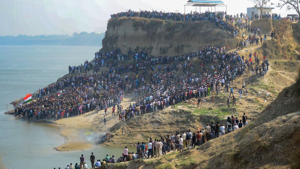 A large number of mourners gather on the bank of the Ganges river to attend the funeral procession for trooper Mahesh Kumar Meena near Allahabad