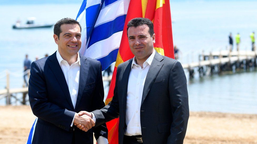 Macedonian Prime Minister Zoran Zaev (R) welcomes Greek Prime Minister Alexis Tsipras on the shore of Lake Prespa on June 17, 2018