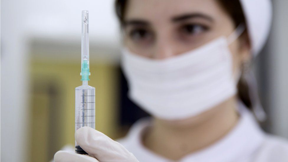 A nurse holding a syringe