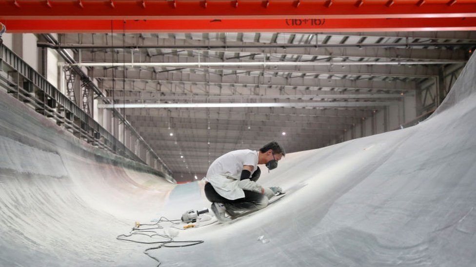 Employees work on the assembly line of wind turbine blade at a factory of Jilin Chongtong Chengfei New Material Co., Ltd on June 7, 2021 in Nantong City, Jiangsu Province of China
