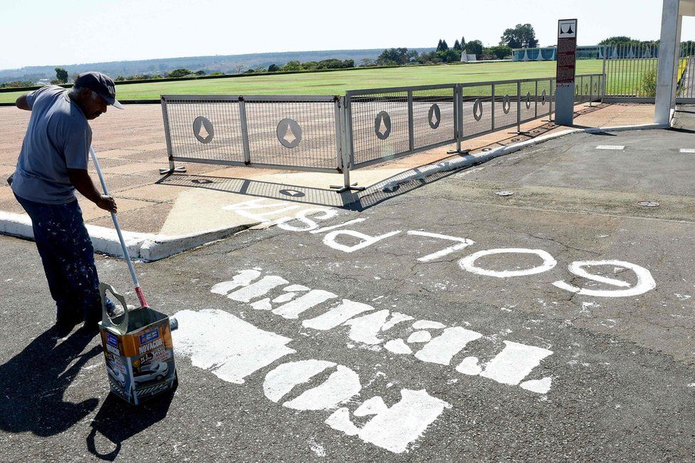 A worker removes the inscription "Temer Out" written on the street in front of the entrance of the Alvorada Palace presidential residence on 1 September 2016 in Brasilia