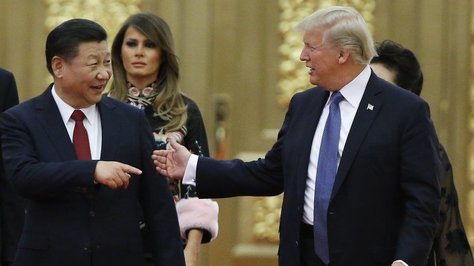 Xi Jinping, left, points at Donald Trump smiling, as if the US president has just told a rather good joke