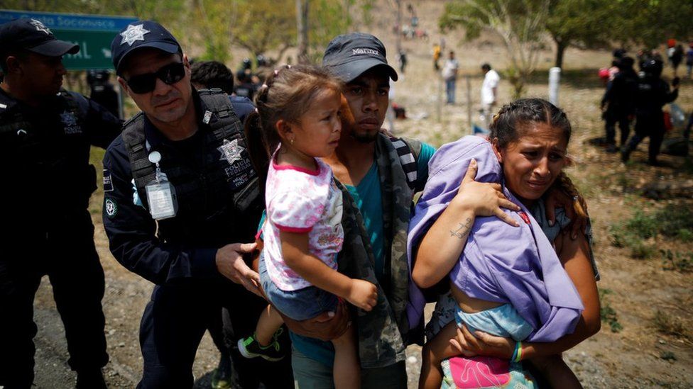 A family of Central American migrants is detained by Federal Police during a raid on their journey towards the United States