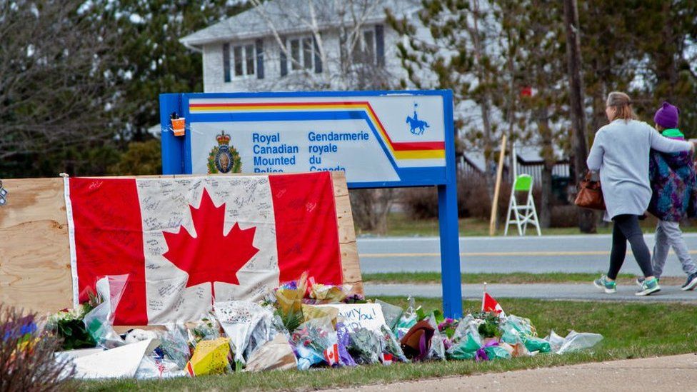 A woman comforts her daughter after they placed flowers at an impromptu memorial in front of the RCMP detachment April 20, 2020 in Enfield, Nova Scotia, Canada. It was the home detachment of slain RCMP Constable Heidi Stevenson, who was one of 19 people killed during Sunday's shooting rampage, including the gunman.