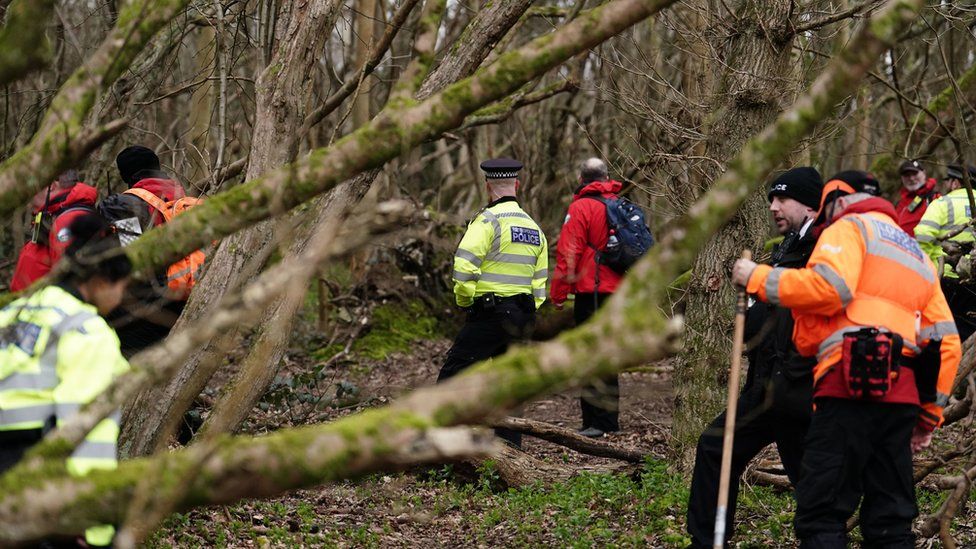 Police officers and officers from London Search and Rescue (LONSAR) in woodland at Wild Park Local Nature Reserve, near Moulsecoomb, Brighton,