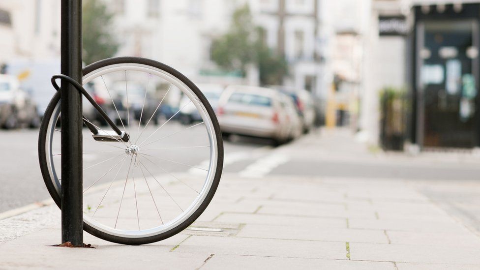 A bike wheel locked to a lamp post