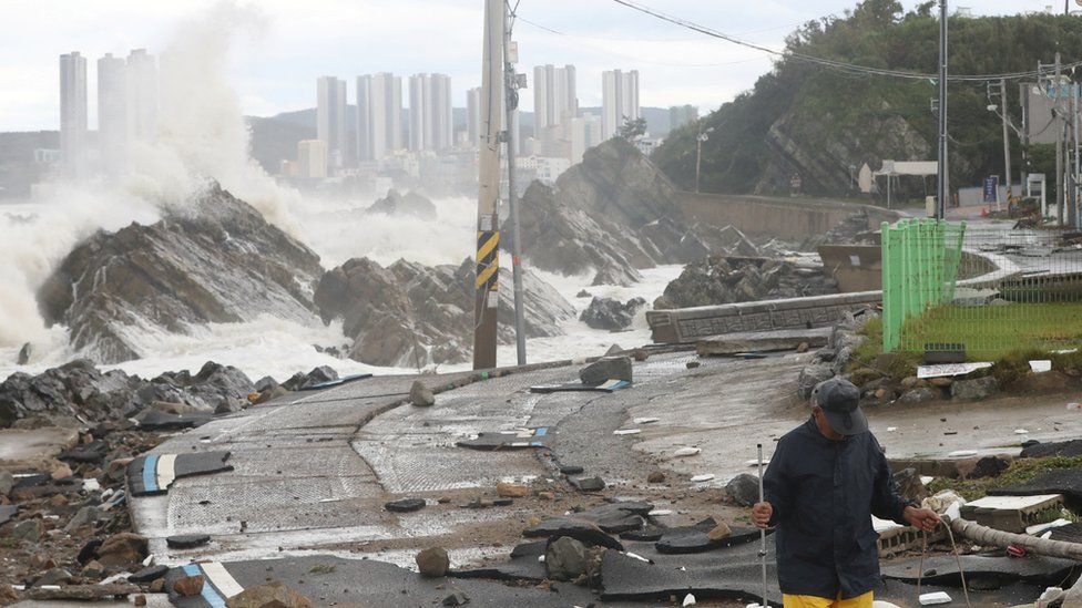 man walks on a road along the coast damaged by Typhoon Hinnamnor in Ulsan
