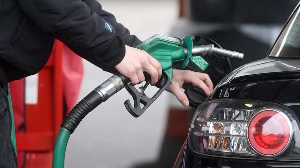 Person filling up a car with petrol