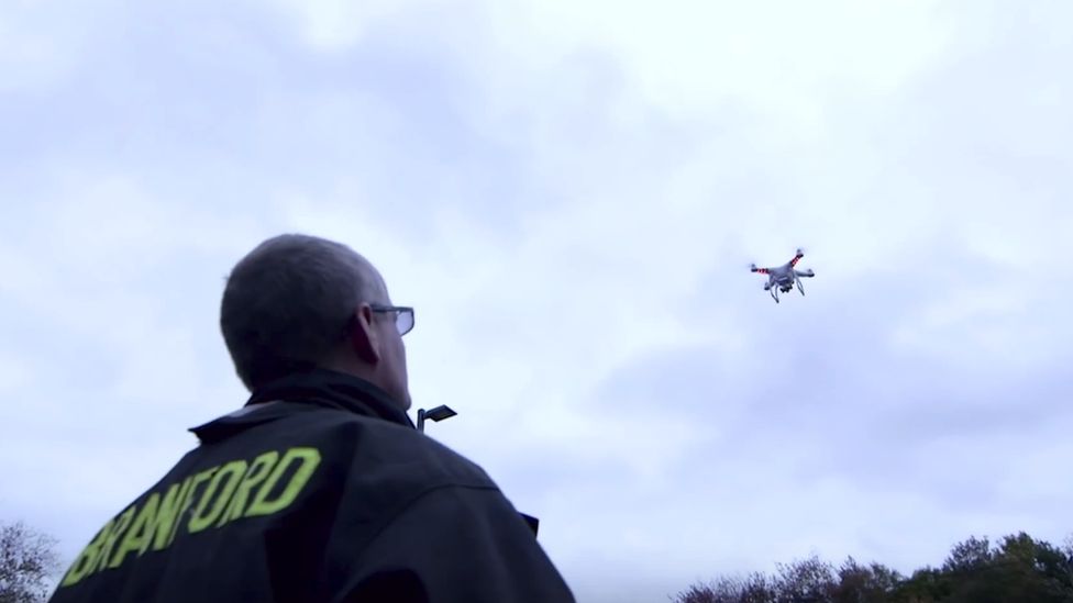 DJI drone being looked at by man
