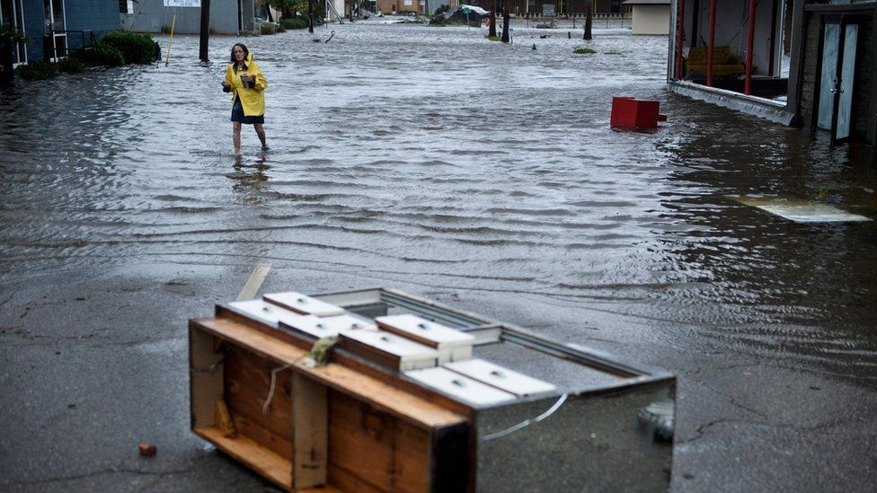 A woman crosses a flooded street after Hurricane Michael made landfall in Panama City, Florida, 10 October 2018