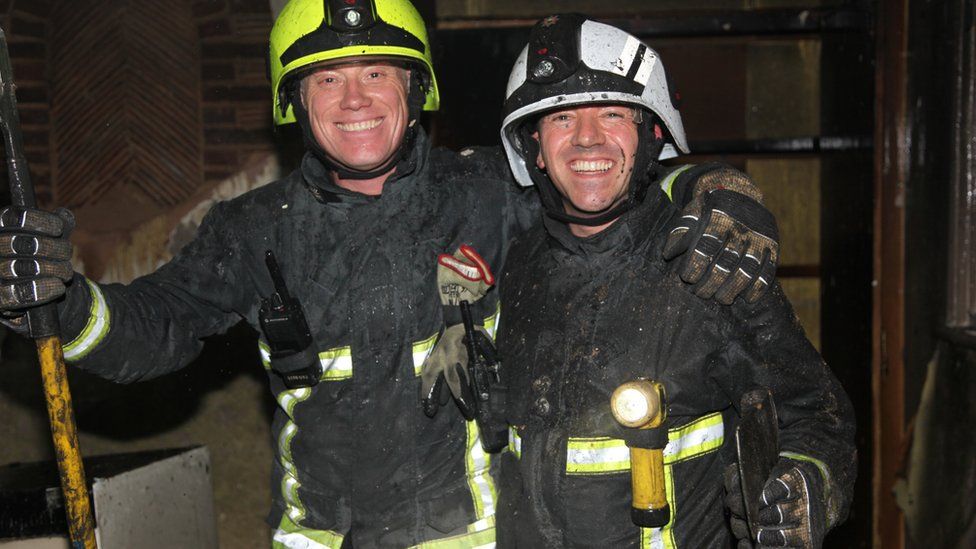 Two firefighters smiling