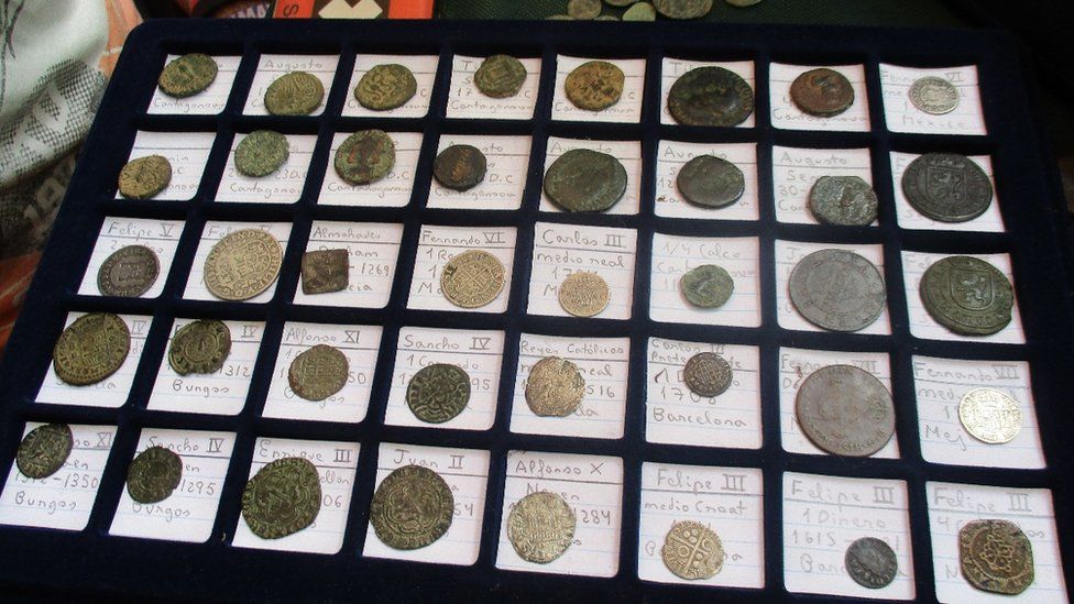 A coin collector's board shows 40 coins arranged in a grid, clearly labelled. Most are pitted with corrosion from great age