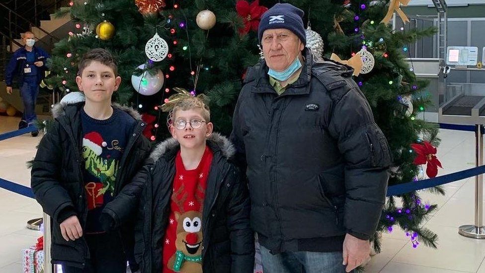 Mrs Noble's father Volodymyr Ternovyi and her two sons George and Joseph at Kyiv Airport last December