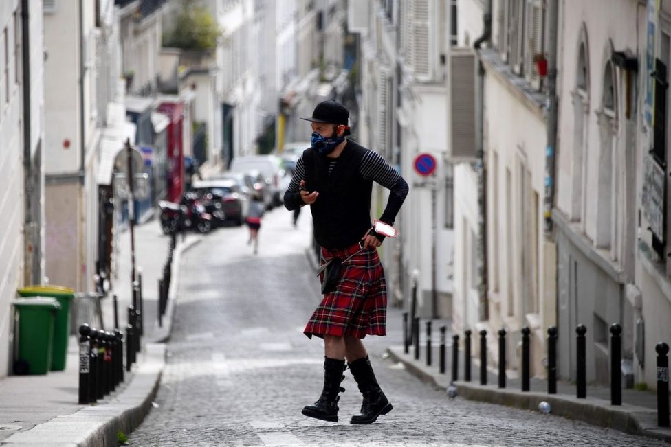 мужчина в шотландской юбке на улицах Монмартра в Париже