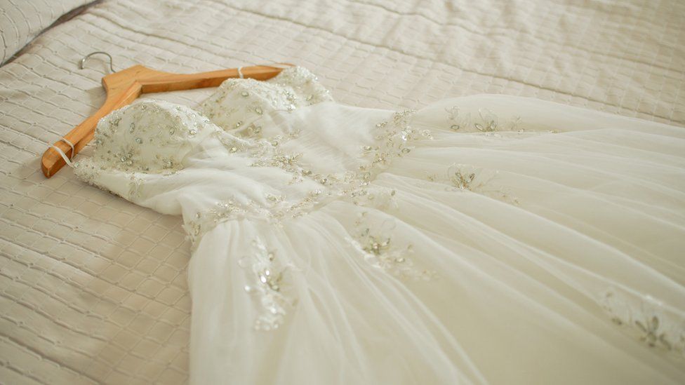 A wedding dress on a bed