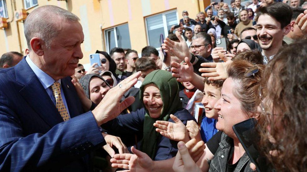 Turkish President Tayyip Erdogan greets his supporters as he leaves a polling station during the local elections in Istanbul