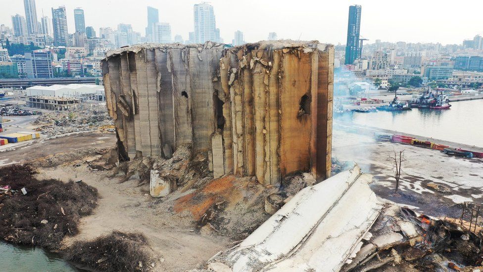 Архивное фото, на котором виден дым, поднимающийся из недавно обрушившейся части зернохранилища в Бейруте, которые были частично разрушены взрывом 4 августа 2020 г. (4 августа 2022 г.)
