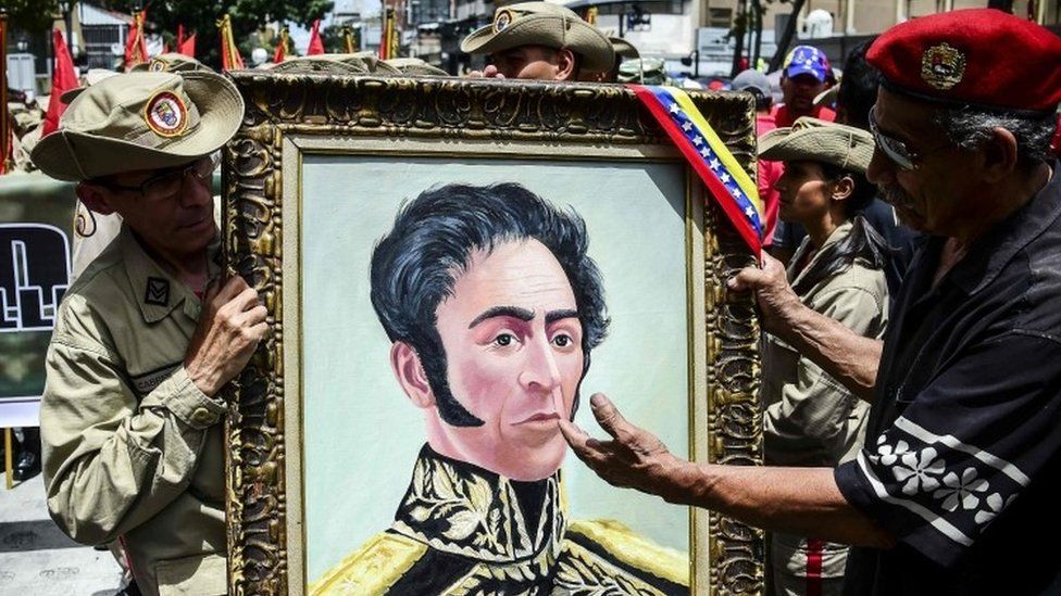 Venezuelan militias hold a portrait depicting Venezuelan Liberator Simon Bolivar as they demonstrate their support to the government of Venezuelan President Nicolas Maduro and against US President Donald Trump, in Caracas, on August 14, 2017.