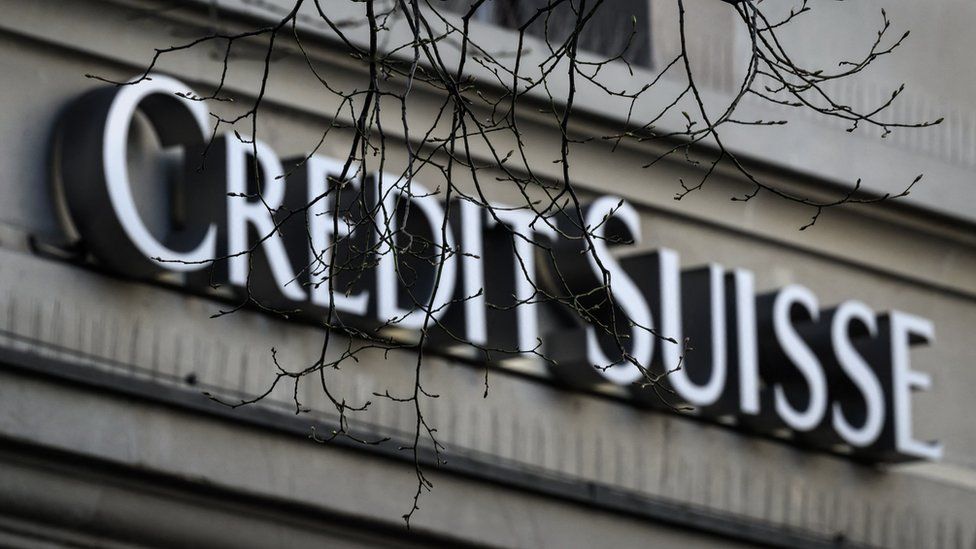 Логотип Credit Suisse с голыми ветвями на переднем плане