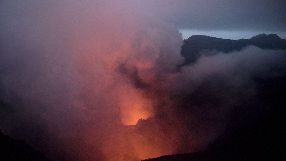 Emissions from the Mount Yasur volcano being lit up by steady eruptions in the crater below on Tanna Island in Vanuatu