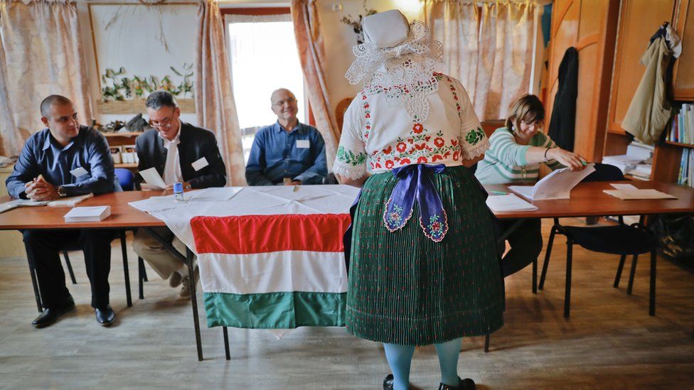 Voter in traditional costume votes in referendum in village of Veresegyhaz, Hungary, Sunday, Oct 2, 2016
