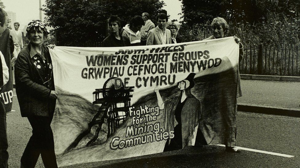 Women marching with banner