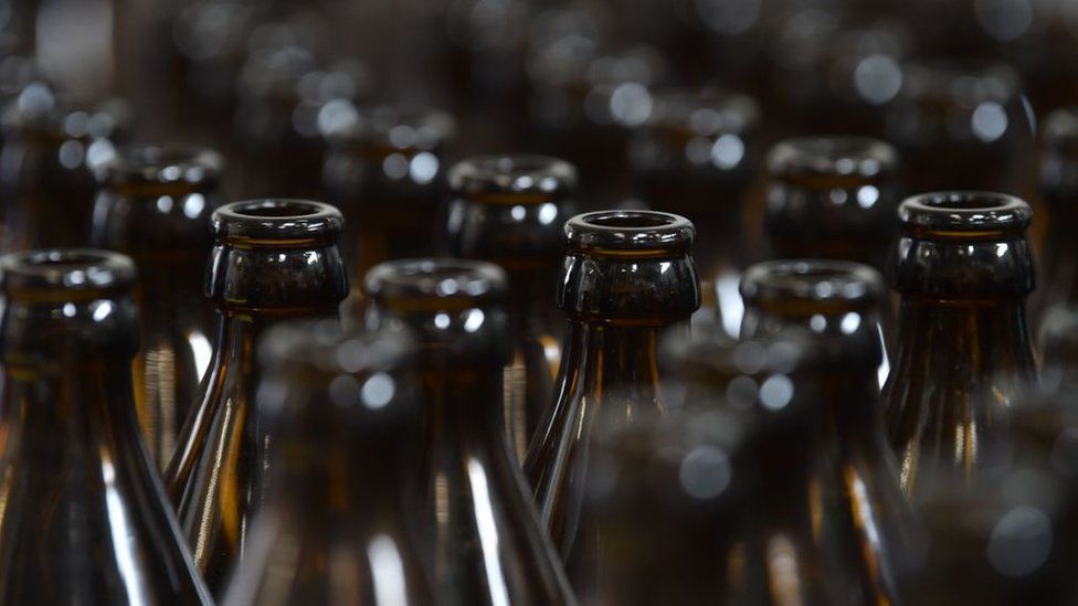 Empty bottles run through a bottling plant for cleaning and new filling in at a brewery in Munich, southern Germany in June 2020