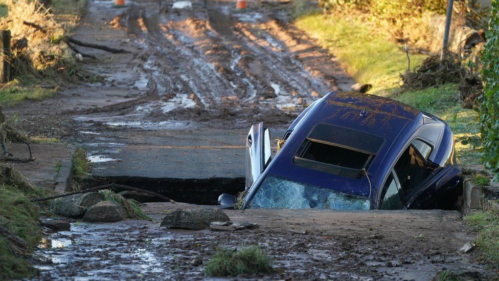 A car is seen on a bridge washed away near Dundee following yesterdays torrential rain as Storm Babet batters the country and a rare red weather warning is in place for parts of eastern Scotland all day on Saturday.