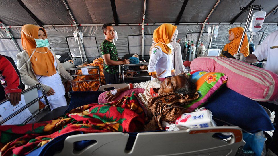 Patients receive medical help at a makeshift ward set up outside the Moh. Ruslan hospital in Mataram