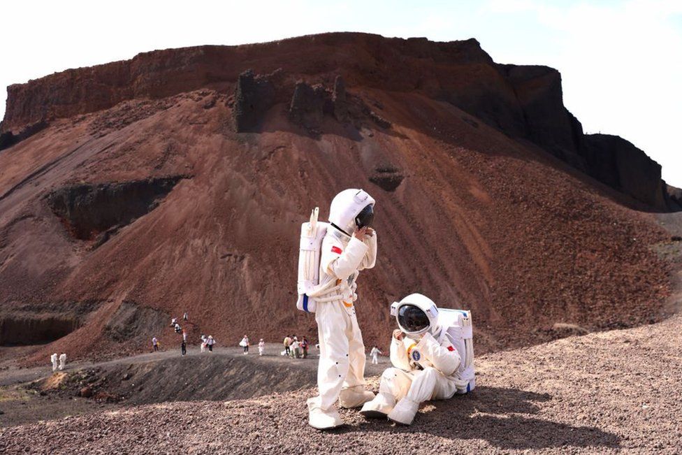 Tourists dressed as astronauts visit the Wulanhada Volcano Geopark on July 17, 2023 in Ulanqab, Inner Mongolia Autonomous Region of China.