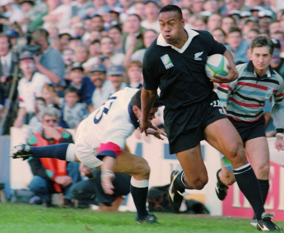 Jonah Lomu runs around England's Will Carling on his way to score the opening try in the Rugby World Cup semi-final in 1995