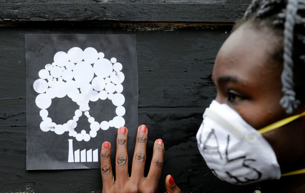 A Greenpeace environmental activist carries a coffin during a protest in Nairobi on 12 June against a coal fired electricity plant planned for the coastal town of Lam.u