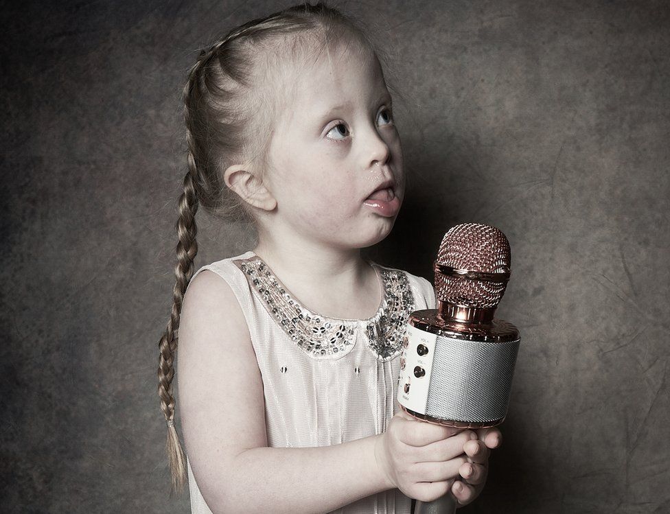 Five-year-old Ava holds a microphone