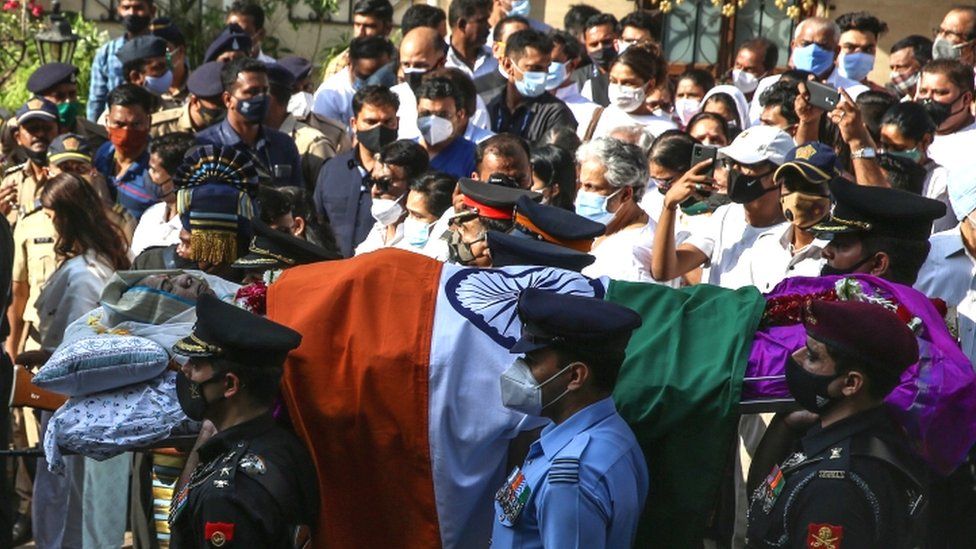Indian defence personnel carry Mangeshkar's coffin outside her house