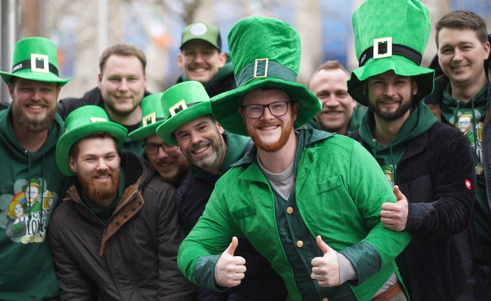 Men wearing green leprechaun hats while they wait for the St Patrick's Day parade in Dublin