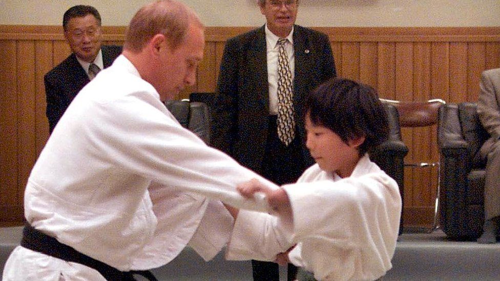 Russian President Vladimir Putin (L) in judo outfit fights against 10-year-old Japanese schoolgirl Natsumi Gomi as he visits a Tokyo judo training center Kodokan hall 05 September 2000. Putin, who has a black belt in the sport, was thrown over her shoulder onto the mat.