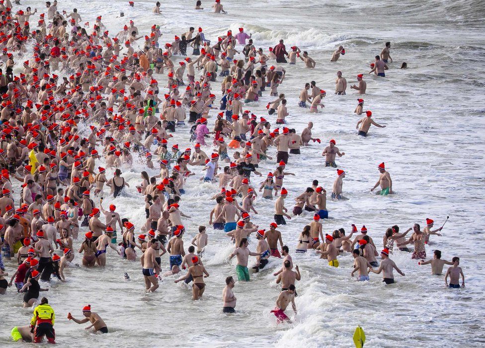 People run towards the North Sea during the "New Year's Swim" in Scheveningen, the Netherlands, 1 January 2018