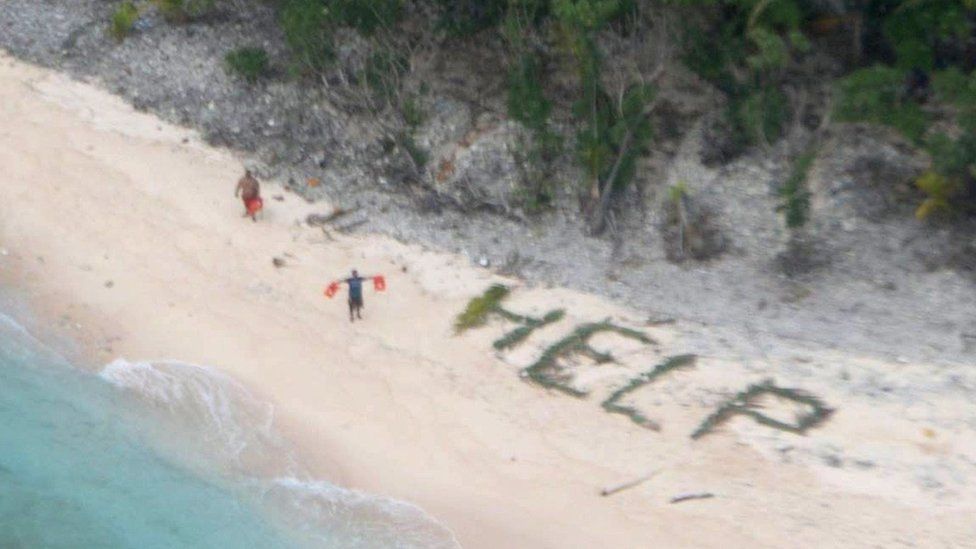 Sailors spell out "help" with palm fronds