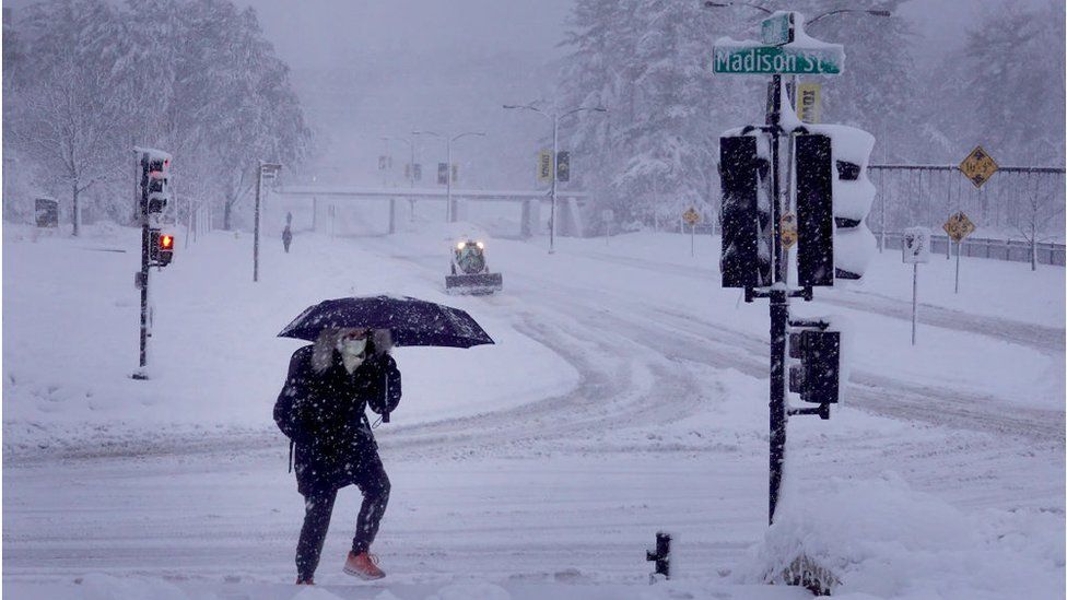 A person navigates the cold snowy streets of Iowa